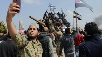 A Turkey-backed Syrian rebel fighter takes a selfie on March 15, 2020during a protest in Idlib against the agreement on joint Russian and Turkish patrols. Reuters