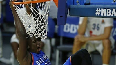 Oklahoma City Thunder guard Victor Oladipo swings on the basket after dunking against Real Madrid. Daniel Ochoa de Olza / AP