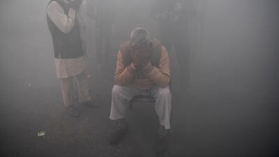 Farmers cover their faces, amid smoke during fumigation by the muncipal corporation, near a road block stopping farmers from marching to New Delhi to protest against the central government's agricultural reforms. AFP