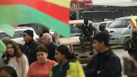 Armed members of the Syrian Democratic Forces watch a demonstration by Syrian Kurds in Hasakah. AFP