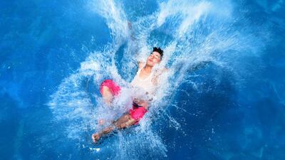An Afghan youth jumps into a swimming pool in Herat. Aref Karimi / AFP