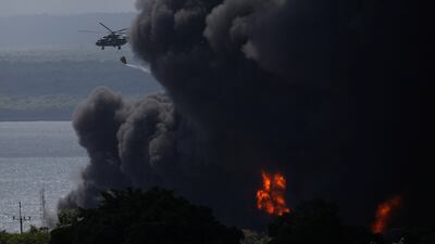 A helicopter drops water over burning fuel storage tanks that exploded near the supertanker port in Matanzas. Reuters