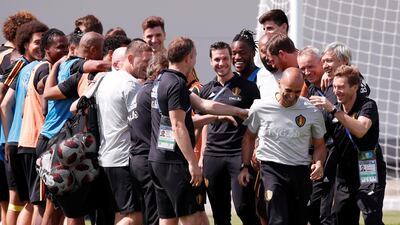 Coach Roberto Martinez is greeted by players and coaching staff at the start of training. Reuters