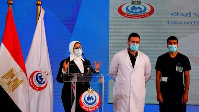 (L to R) Egyptian Health Minister Hala Zayed gives a press conference, accompanied by doctor Abdelmouim Selem and medical staff member Ahmed Hemdan, in a tent set up outside the Abou Khalifa hospital, in Ismailia after the two men received a dose of a coronavirus vaccine. AFP