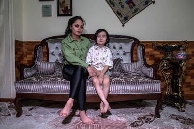 Tattoo artist Soraya Shahidi, 26, sits with her son in her house in West Kabul. Stefanie Glinski for The National