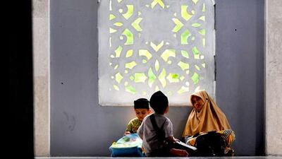 Young Indonesian Muslims wait for Mahgrib prayers a mosque in Banda Aceh. Chaibeer Mahyuddin / AFP Photo