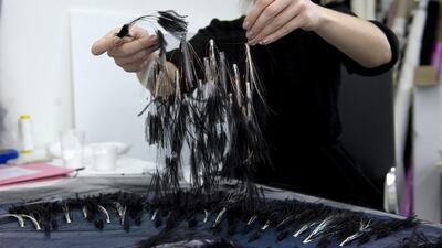 At the Lemarié Ateliers, the ostrich feathers are attached to the lurex fringes and applied to the tulle of the overskirt — with the help of a pair of pliers and a dot of glue. (Courtesy: Chanel)