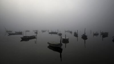 Fog obscures the lagoon of Messolongi, in western Greece, as fishing boats are anchored along the boardwalk. Dimitri Messinis / AP Photo