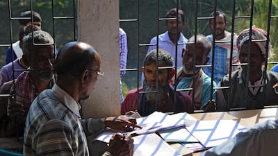 People wait to check their names on the first draft of the National Register of Citizens (NRC) at Goroimari of Kamrup district in the Indian state of Assam on January 1, 2018. Kulendu Kalita / AFP