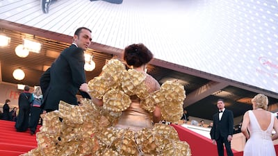 A guest, wearing a dress made of biscuit trays, arrives for the screening of the film "The Past". Alberto Pizzoli / AFP