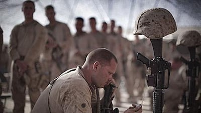 A US marine of the 3rd Battalion, 6th Marines, holds the dog tag of a fallen comrade during a memorial ceremony for four fallen soldiers at their base in Marjah, Helmand province, southern Afghanistan.
