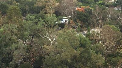 A helicopter hovers above a site damaged by mudslide in Montecito, California. Ventura County Sheriff's Office / via Reuters