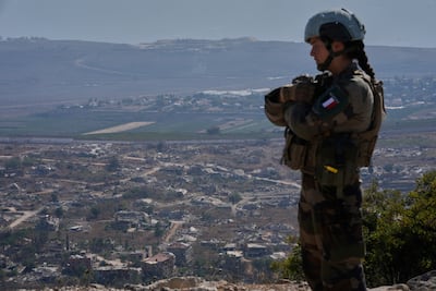 A UN peacekeeper stands on a hill overlooking a Lebanese border village destroyed by Israeli airstrikes. AP