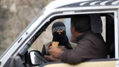 A female member of the Al Ikhlas (loyalty) battalion, stops a van at a checkpoint in Aleppo. The battalion is under the Ghorabaa (strangers) Al Sham Front, controlled by the Free Syrian Army.
