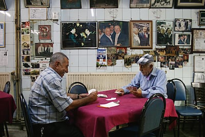 Men play cards at Yashar Hoca’s Place, in Recep Tayyip Erdogan's old Istanbul neighborhood, Kasimpasha, surrounded by photos of Mr Erdogan and other Justice and Development Party (AKP) politicians. Piotr Zalewski for The National
