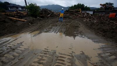 A police officer stands next to debris swept away by heavy rain in Asakura, Fukuoka Prefecture, Japan July 9, 2017. REUTERS/Issei Kato