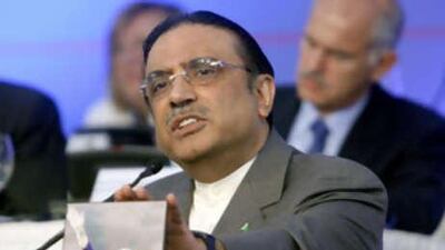 Asif Ali Zardari, husband of slain politician Benazir Bhutto, touches her photo during his speech to the twenty-third Congress of the Socialist International at the Lagonissi Grand Resort, Greece.