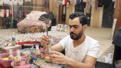 Nadim Tantawi crafts a decorative sand bottle at his stand in the empty visitors centre at Jerash, Jordan on October 21, 2020. Taylor Luck for The National