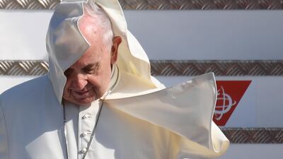 A breeze catches and blows up Pope Francis' collar as he disembarks from the plane. EPA