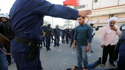 Police and protesters stand around a man who collapsed following clashes in the Duraz village north of the Bahraini capital Manama.
