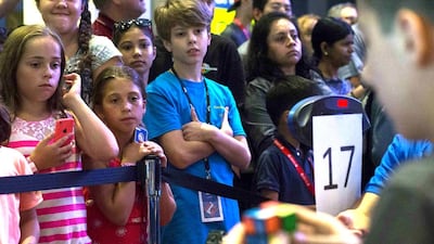 Children watch a competitor at the National Rubik’s Cube Championship at Liberty Science Center in Jersey City, New Jersey August 1, 2014. Reuters