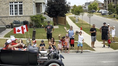A Canada Day drive-by parade makes its way through town on July 1, 2020 in Newcastle. After living in several countries, Kareem Shaheen has settled down with his family in Canada. AFP