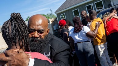 Relatives of victims of the Shreveport shooting gather outside the house where the incident took place. AFP