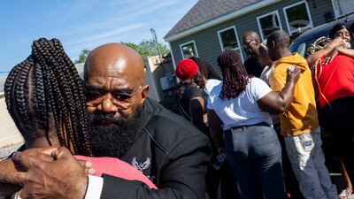 Relatives of victims of the Shreveport shooting gather outside the house where the incident took place. AFP