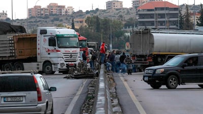 Anti-government protestors block the road on the Sidon-Beirut highway on Friday as protests which began in October rumble on. AFP