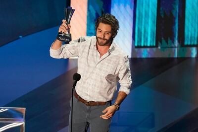 Thomas Rhett accepts the entertainer of the year award in a tie with Carrie Underwood. AP