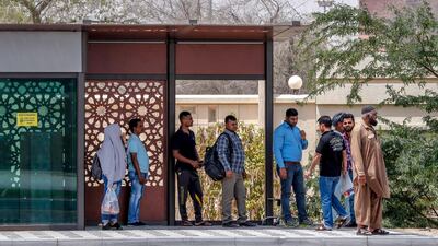Commuters wait outside a bus stop on Saif Ghobash Street. Victor Besa / The National