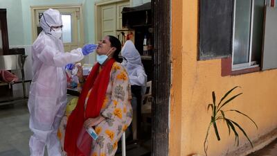 A health worker collects swab sample to test for Covid-19 at a government dispensary in Mumbai, India. AP Photo