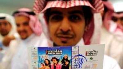 A man holds up his ticket to see the Saudi film Menahi last December in Jeddah.