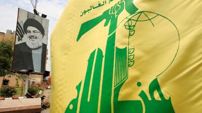 A Hezbollah flag and a poster depicting its Secretary-General Hassan Nasrallah are pictured near Sidon, Lebanon. Reuters