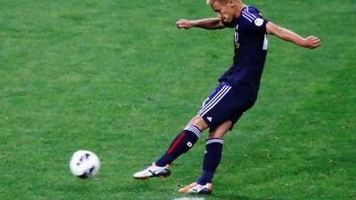 Japan's Keisuke Honda scores on a penalty kick against Australia on Tuesday and the 1-1 draw qualified Japan for next year's World Cup. Toru Hanai / Reuters