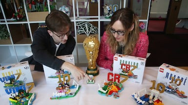Model designer Freddy Charter, left, and design master Beatrice Amoretti display the Lego Editions sets of footballers Vinicius Jr, Lionel Messi, Cristiano Ronaldo and Kylian Mbappe. Reuters