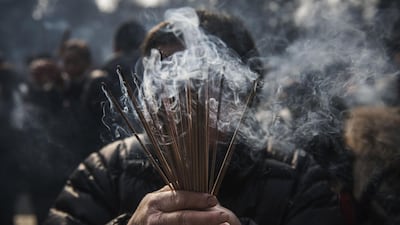 A woman prays for good fortune on the first day of the Lunar New Year in Beijing, China. Getty Images