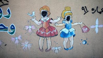 A mural with faces blotted out by ISIL militants is seen on the wall of a kindergarten school in Mosul.