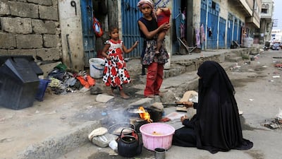 A displaced Yemeni woman prepares food for her children outside their one-room rental house at a street in Sanaa, Yemen. EPA