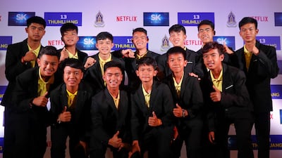 Members of the Thai Wild Boards football team and their coach Ekapol Chantawong, top centre, have agreed that Netflix can produce a film based on their real-life rescue. EPA