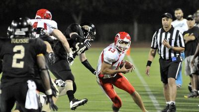Dubai Stallions Quarterback, Andrej Tasic, heads out of bounds with the ball during Friday night's Desert Bowl at Dubai Sports City. Charles Crowell for The National / March 14, 2014