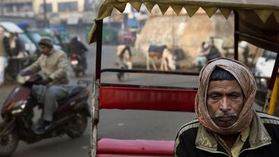 A rickshaw puller waits for customers outside a metro railway station, in New Delhi, India. Mannish Swarup / AP