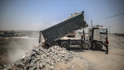 Delivering the rubble of buildings destroyed during the May rocket attacks. Sanad Latefa for The National