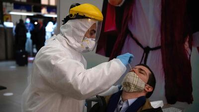 A health worker collects a nasal swab sample from a passenger to be tested for Covid-19 before he is allowed to board a ferry to Buenos Aires. AFP