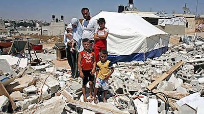 Hafez al Rajabi stands with his wife Dalal and children stand amid the ruins of their home in Beit Hanina in East Jerusalem.