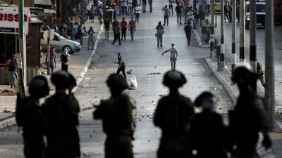 Israeli soldiers stand guard in front of Palestinian stone throwers during clashes in the West Bank town of Bethlehem (AFP PHOTO / THOMAS COEX)