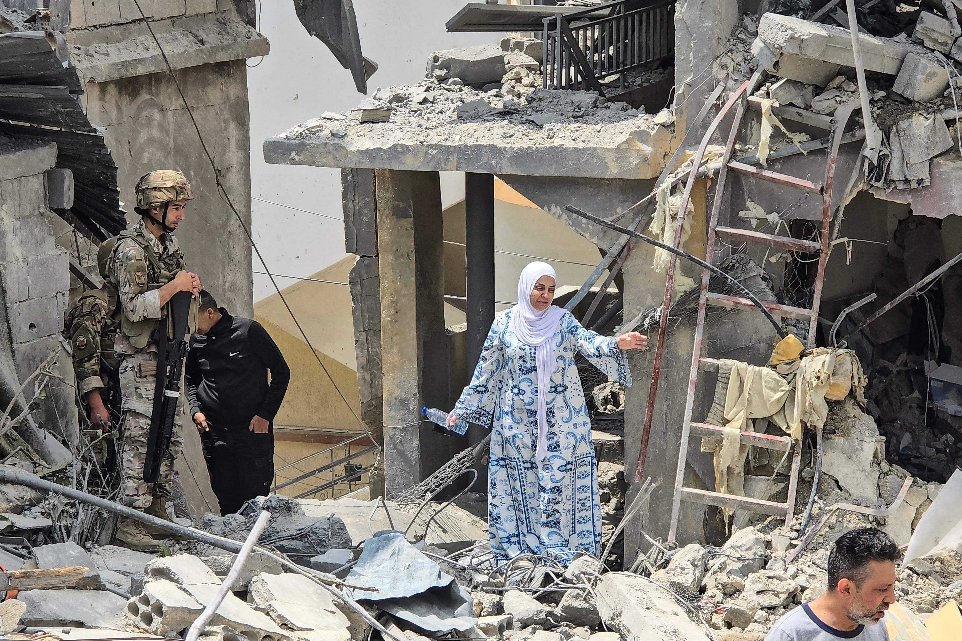 A woman makes her way through the rubble of a residential building hit in an Israeli attack, near Burj Al Shamali, on the outskirts of Tyre. AFP