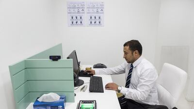 A VFS employee demostrates how biometric scanning is used for Saudi Arabian visa applications. Antonie Robertson / The National