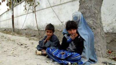 Mawjuda begs on a street in Kabul with Nazar and Parmena, who she said were her children.
