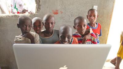 Rural Kenyans get a first look an Apple laptop during a technology outreach effort. David Mbiyu / Demotix